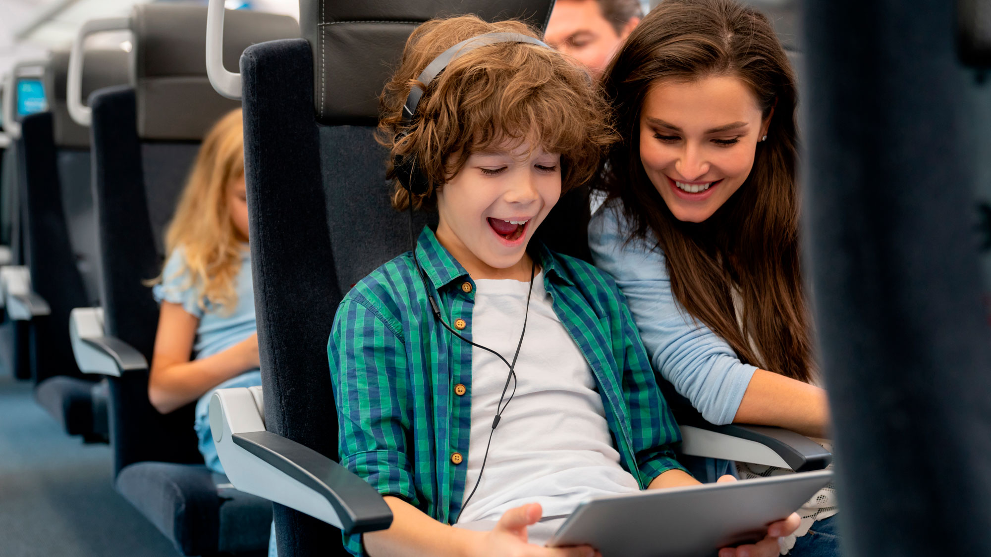 Illustrasjon av barn med iPad og voksen på et fly på vei til ferie