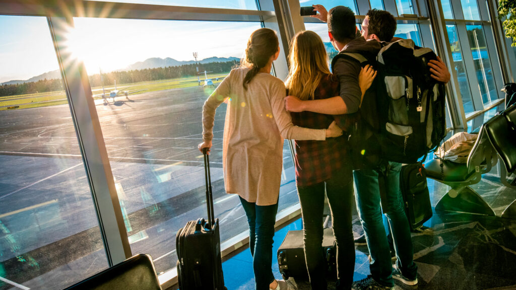 Illustrasjon av fire mennesker som tar et bilde før innsjekk på en flyplass på vei til ferie.